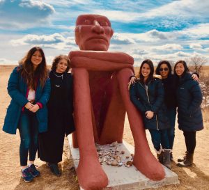 Five women pose by statue at Standing Rock Lakota Sioux Reservation