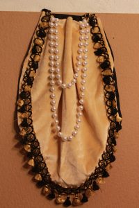 petal-shaped gold velvet costume part with draped pearl embellishmen and tassel fringe.