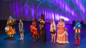 Winners of costume design awards in line on stage wearing their costumes.