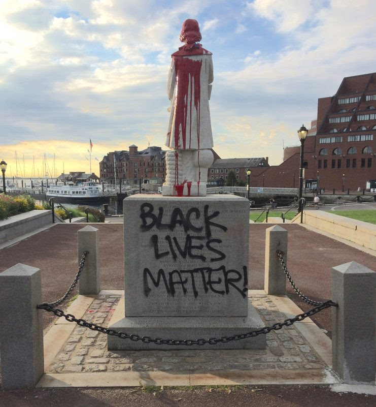 Black Lives Matter and red paint on defaced statue of Christopher Columbus in Boston’s North End waterfront park.