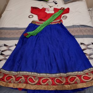 The dhavani paired with a full outfit, spread out on the bed.