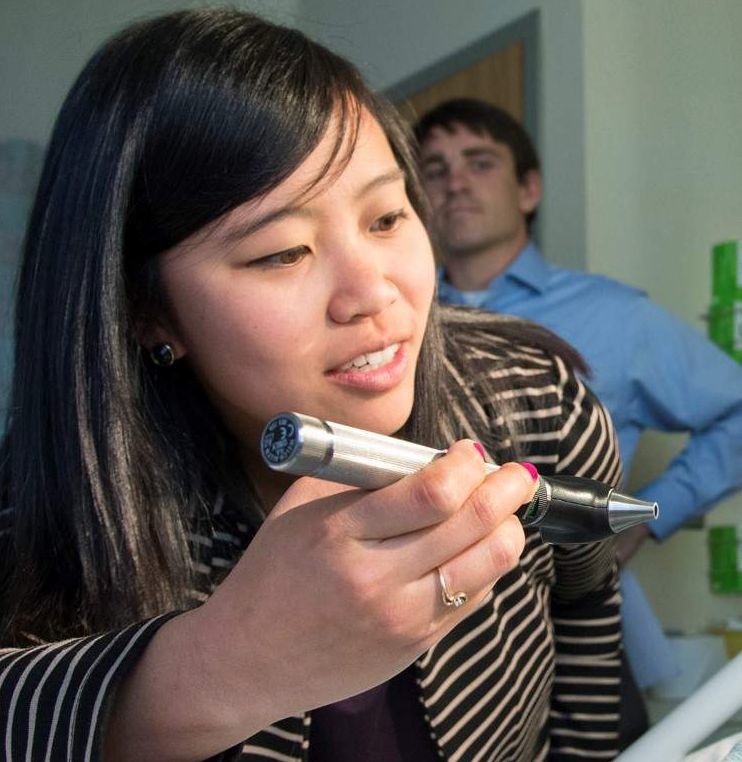 A UWSOM student examining the mouth at a hospital tutorial.