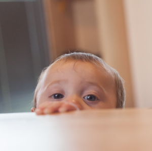 Child looking across table to something unseen