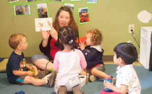 Adult reading picture book to a group of children