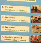 classroom rules listed in both English and Spanish. The accompanying pictures show students in the class demonstrating each rule.