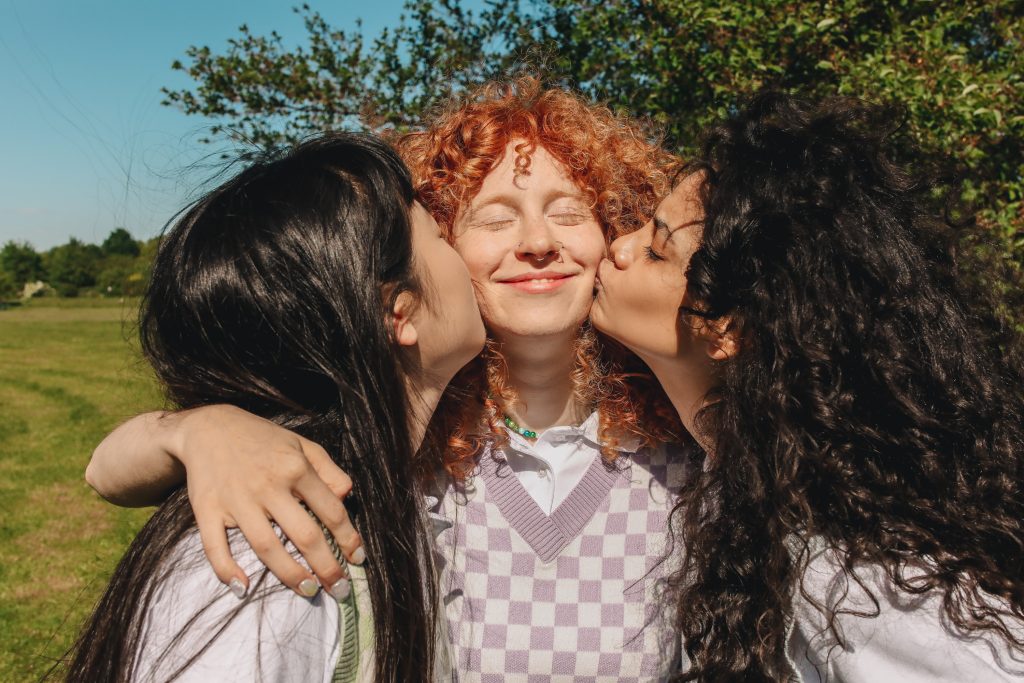 Photograph of Girls Kissing Their Friend on the Cheek by Polina Tankilevitch on pexels.com