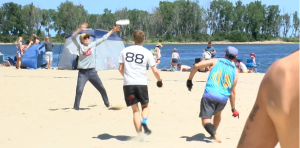 This is a picture of a group of people playing Frisbee on the beach