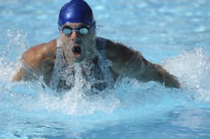 A man in the water engaging in butterfly stroke.