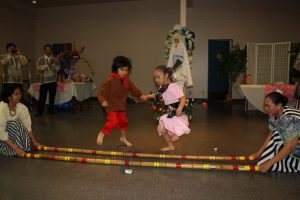 2 young dancers wearing barrio fiesta suite costumes dancing tinikling