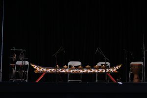 An eight piece knobbed gong set resting on a stand