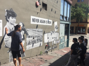 Photograph of YouthCAN sight-seeing Nihonmachi Alley in the CID, specifically the Never Again is Now mural by Amy Nikaitani