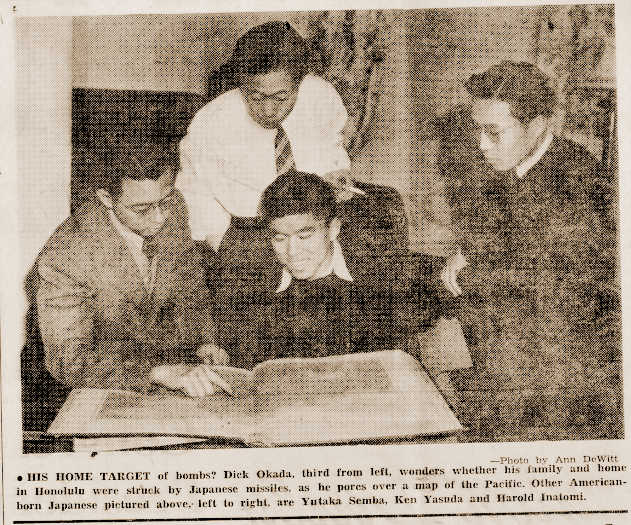 UW Daily photo of Nikkei students looking at an atlas to locate Pearl Harbor.