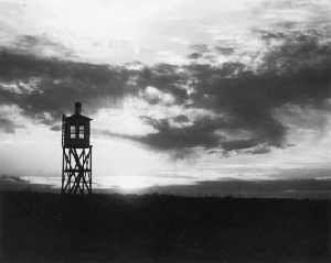 Guard tower silhouetted against susnet.