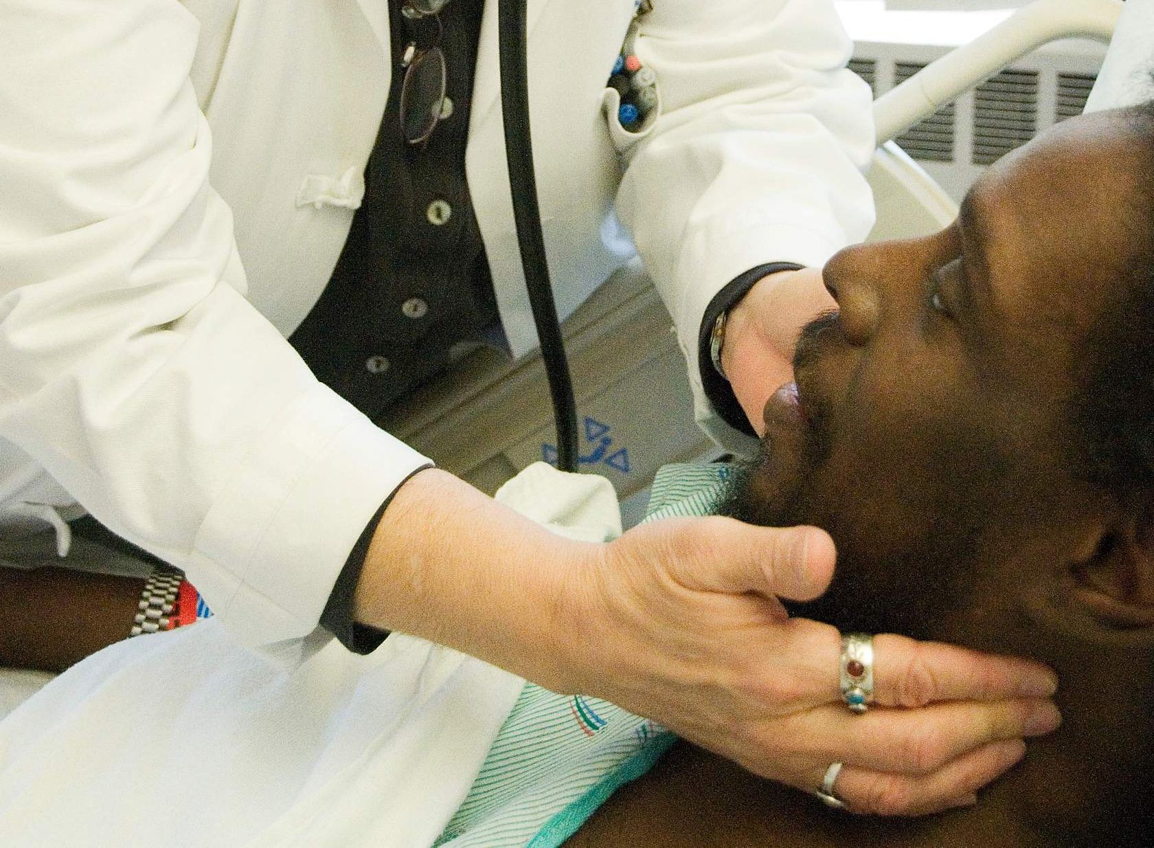 image of a physician palpating a patient's neck for enlarged lymph nodes