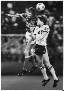 A dynamic action shot of a Seattle soccer match, with players in mid-play, showcasing the intensity and movement of the game.