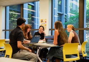 Five students gathered around a table in the library.